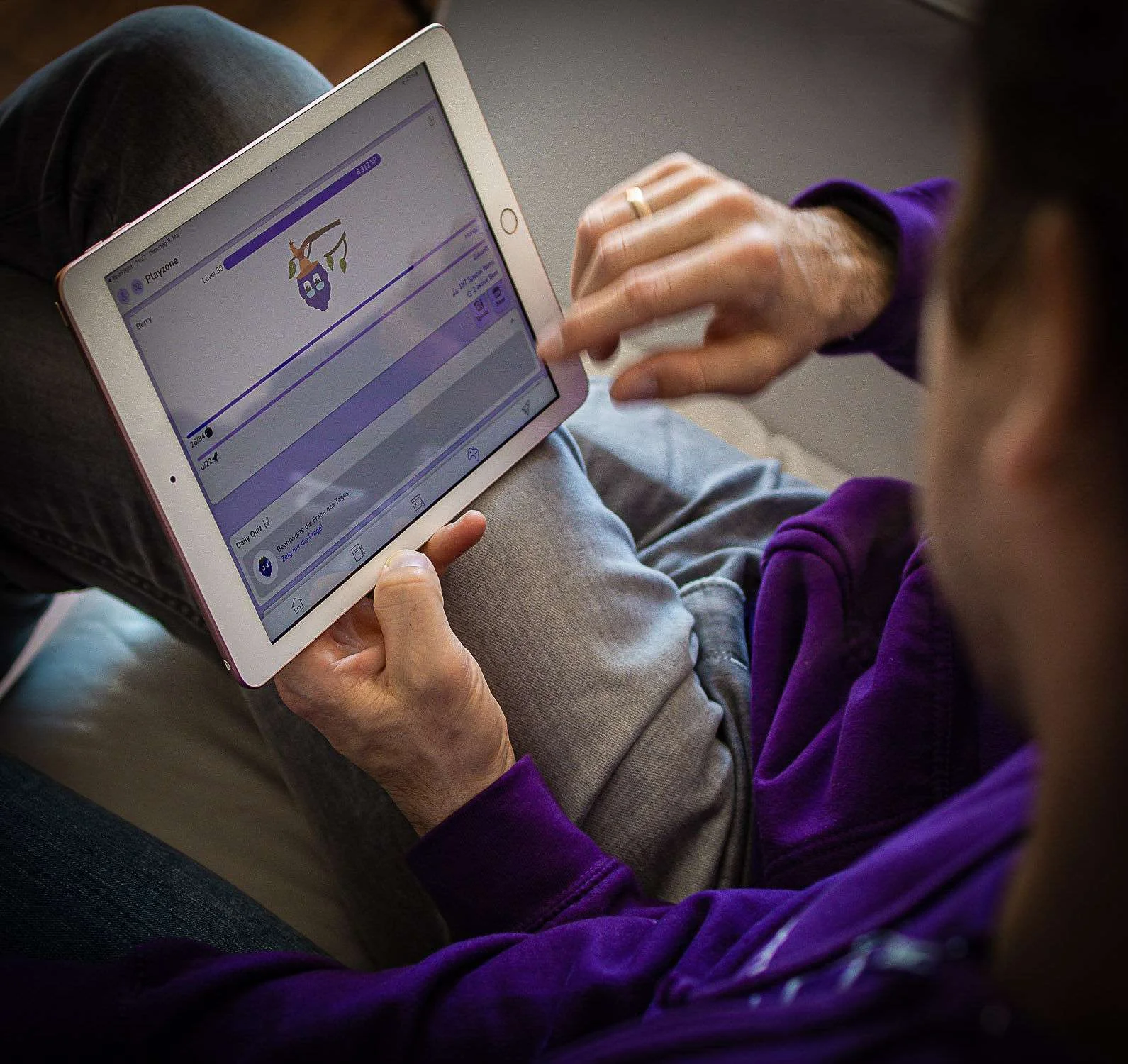 A student holding a tablet showing the Playzone with Berry