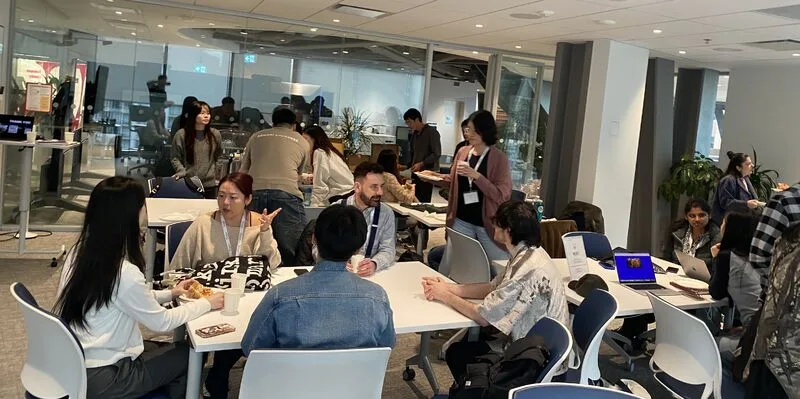 Attendees and hiring managers talking at tables during the Portfolio Review