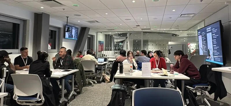 Attendees working on laptops in the evening at the Portfolio Wireframing Workshop